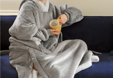 Model-wearing-gray-full-length-Wearable-Blanket-sitting-on-coach-cropped_Bedsure-Amazon-photo_09.2021-524x485