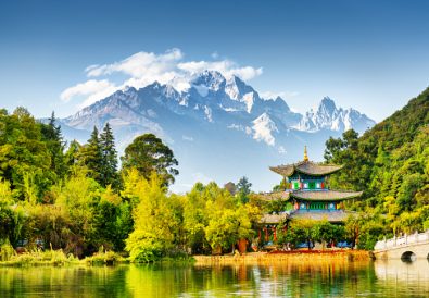 Scenic view of the Jade Dragon Snow Mountain and the Moon Embracing Pavilion on the Black Dragon Pool in the Jade Spring Park, Lijiang, Yunnan province, China.