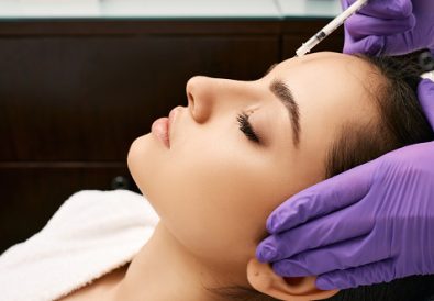 Botulinum toxin injections to beautiful woman's forehead, side view. Anti-aging procedure after 30 years, cosmetologist doing beauty injection