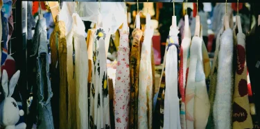 Colorful vintage clothing on display at an outdoor flea market