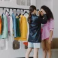 Fashion stylist assists client in a vibrant wardrobe fitting, ensuring perfect accessory choices