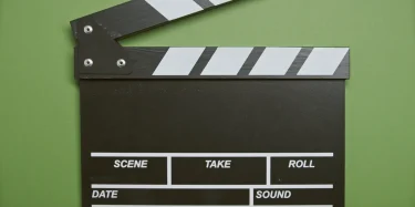 A classic film clapperboard on a green surface, essential for movie scenes