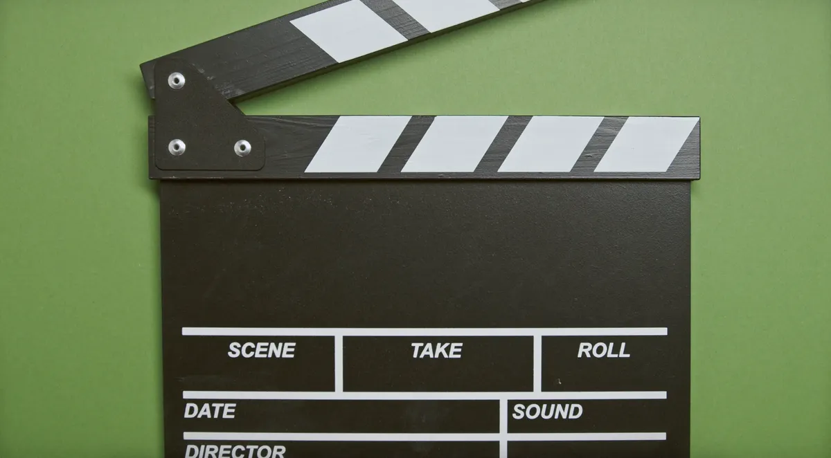 A classic film clapperboard on a green surface, essential for movie scenes