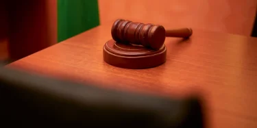 A close-up of a gavel on a courtroom desk representing law and justice