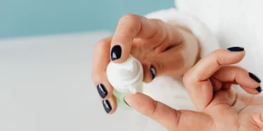 Detailed shot of hands applying skincare cream with gentle focus