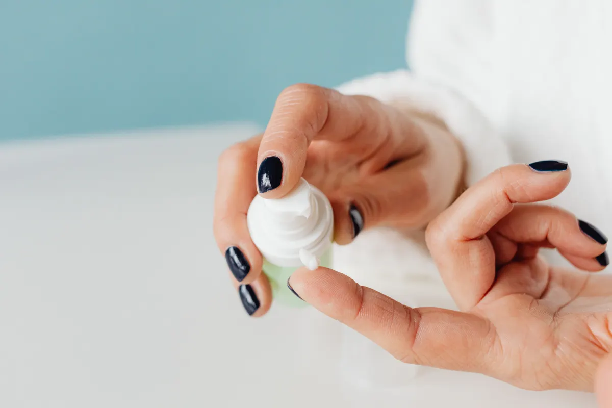 Detailed shot of hands applying skincare cream with gentle focus